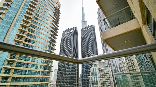 A view of tall, modern buildings with reflective glass facades, including a prominent skyscraper with a pointed top. - New 1BR Apt - Burj Khalifa View - LOFT (Dubai)