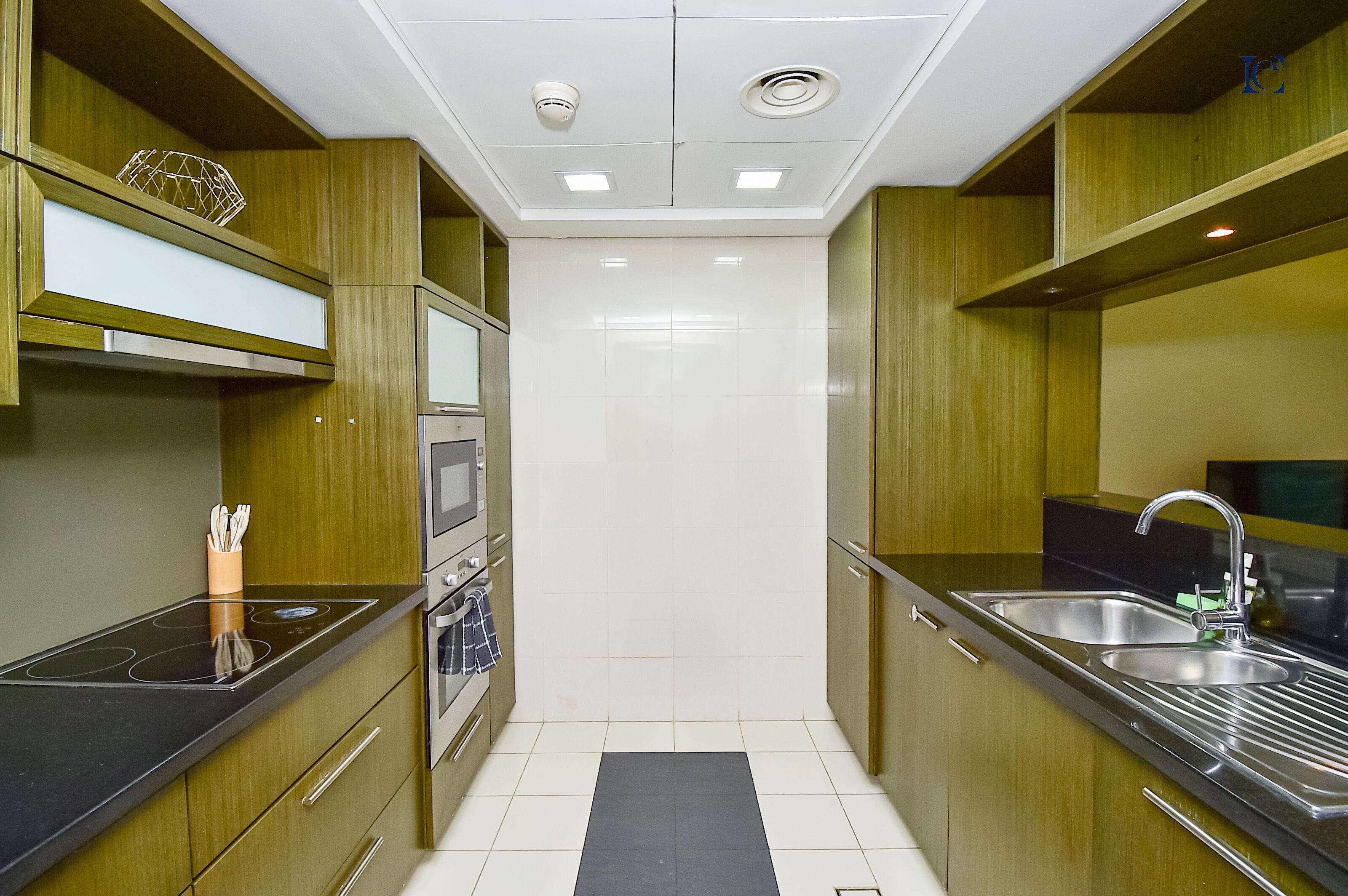 Une cuisine moderne avec des meubles en bois, des appareils en acier inoxydable et un plan de travail noir.