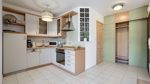 A modern kitchen with white cabinets, a microwave, a stove, and a sink. There is a window with a view of the outside.
