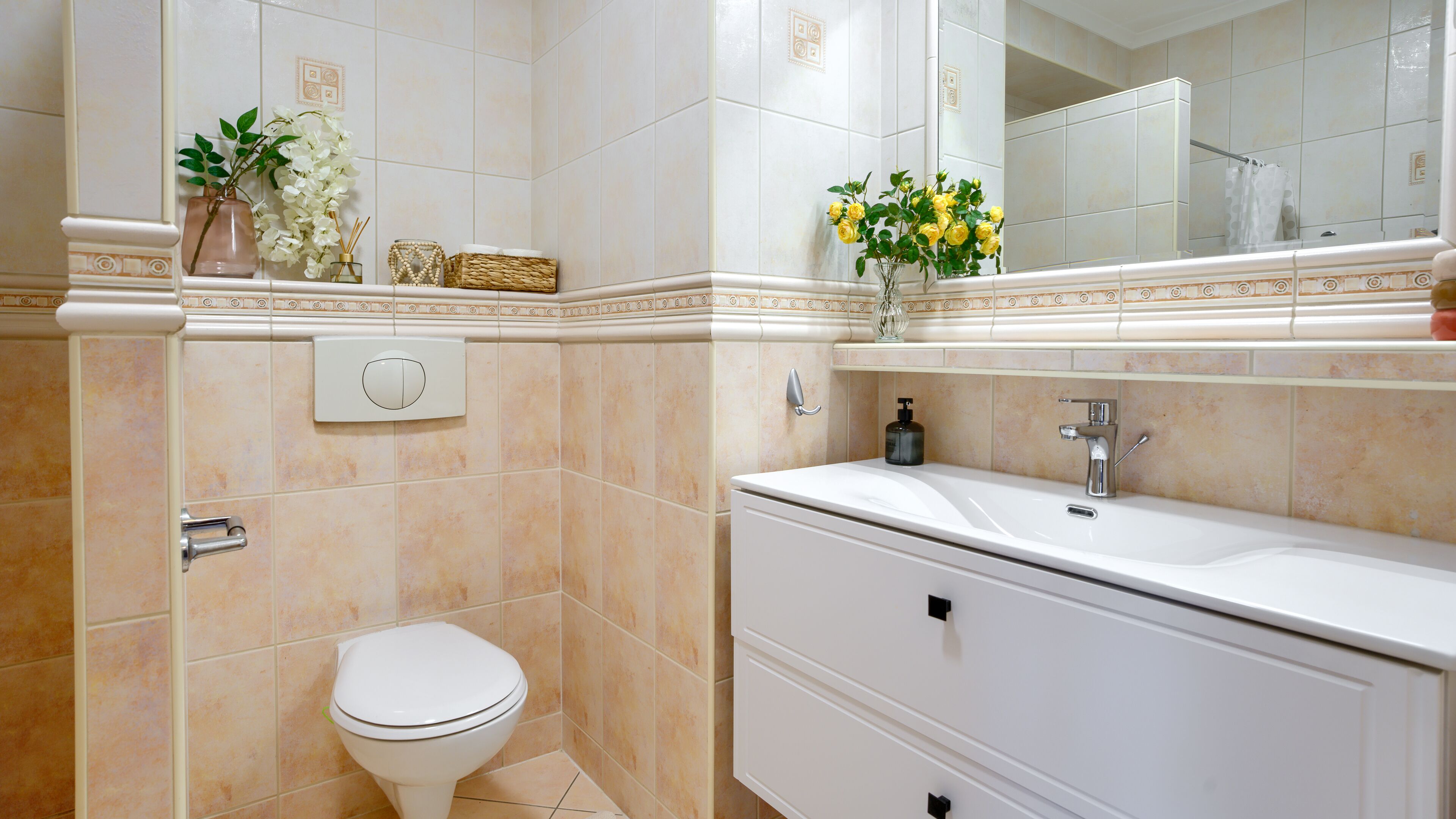 A bathroom with a toilet, a sink, and a mirror.
