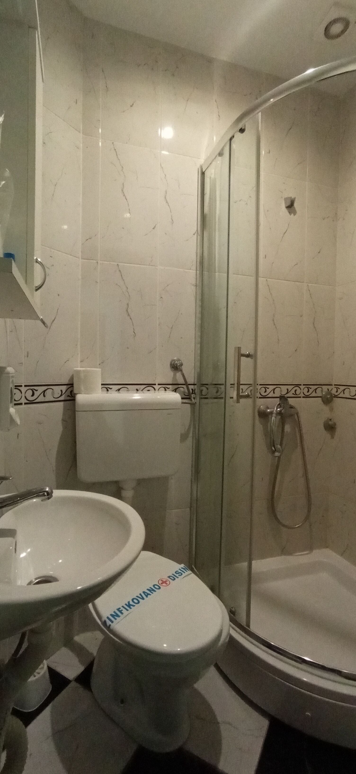 Une salle de bain avec une douche à parois de verre, un lavabo et des toilettes.