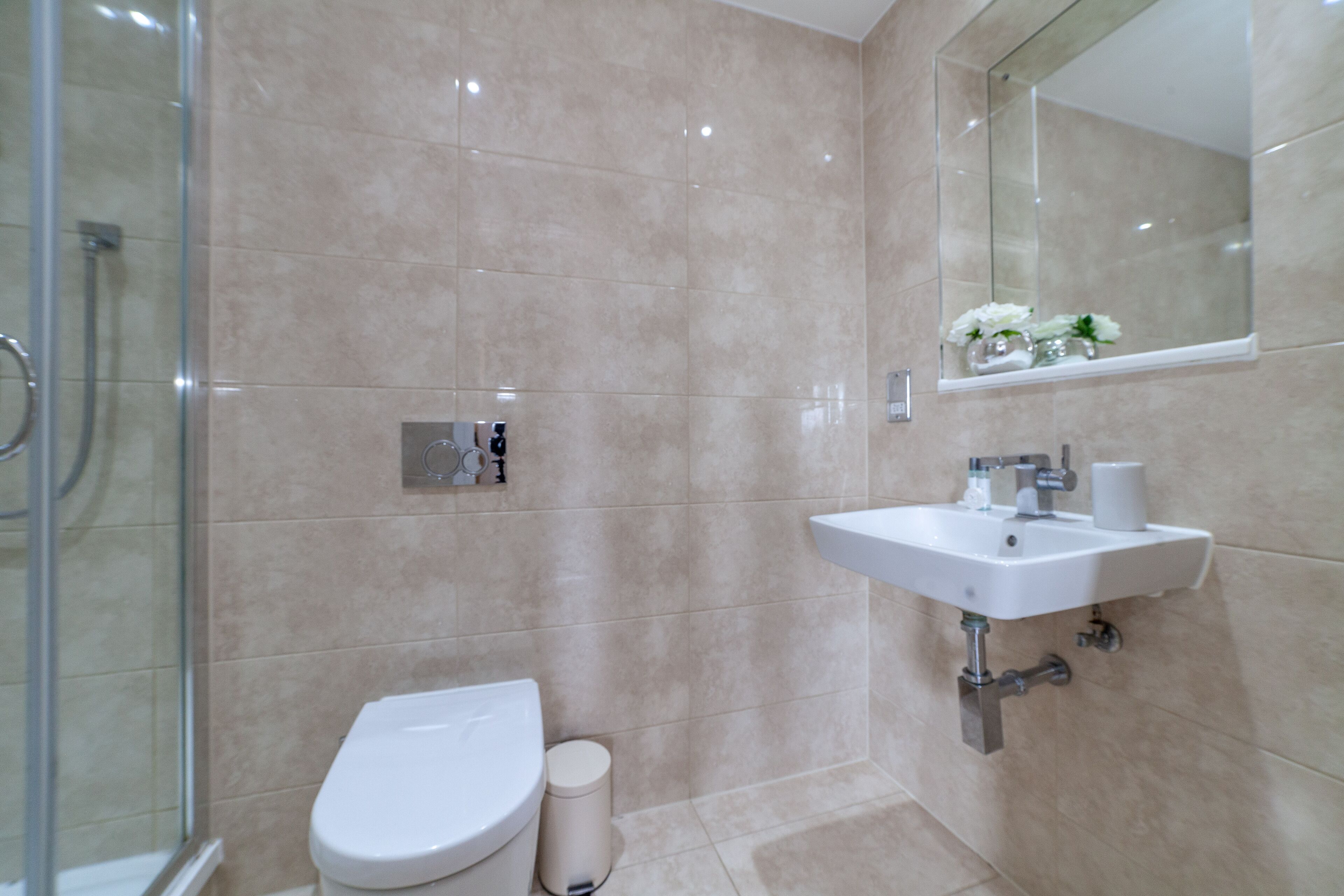 A bathroom with a toilet, sink, and shower.