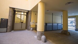 Ein Gebäudeeingang mit Glastür, einer Treppe und einem Empfangsbereich.
