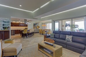 A spacious living area with a sofa, coffee table, and dining chairs. - Molino De Agua Beachfront 3-Bed Oasis w/ Pool, Spacious Balcony & Ocean Views (Puerto Vallarta)