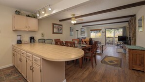 Una cocina amplia con una isla grande, armarios de madera y un comedor con sillas y una mesa.