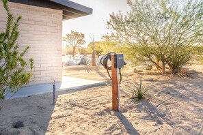 Paisatge desèrtic amb un edifici modern, façana de maó i estructura metàl·lica en primer terme.