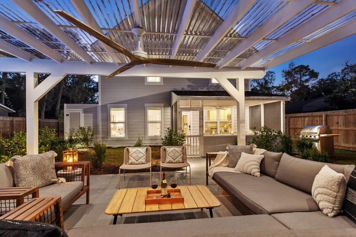 A covered outdoor patio with a sofa, chairs, and a table.