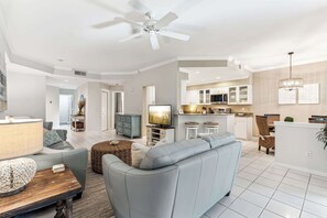 A modern living room with a sofa, TV, and dining area.