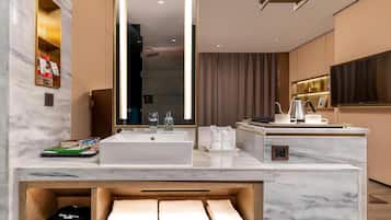 A modern bathroom with a large mirror, a white sink, and a vanity area.
