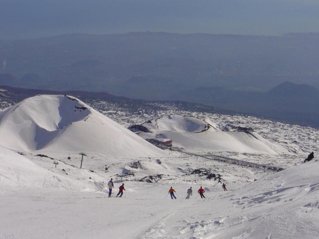 Un paysage de montagne enneigé avec des skieurs.