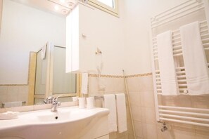 A bathroom with a sink, mirror, towel rack, and shower. - Etna Dimora dei Saponari (Trecastagni)