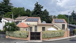 A residential building with solar panels, a gated entrance, and a staircase leading to the upper floor. - Etna Dimora dei Saponari (Trecastagni)