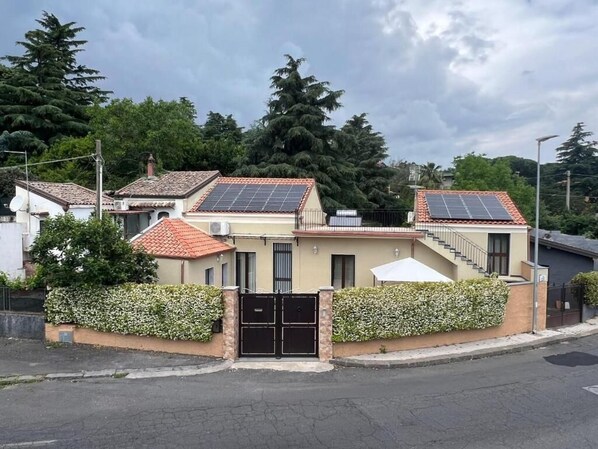 A residential building with solar panels, a gated entrance, and a staircase leading to the upper floor. - Etna Dimora dei Saponari (Trecastagni)