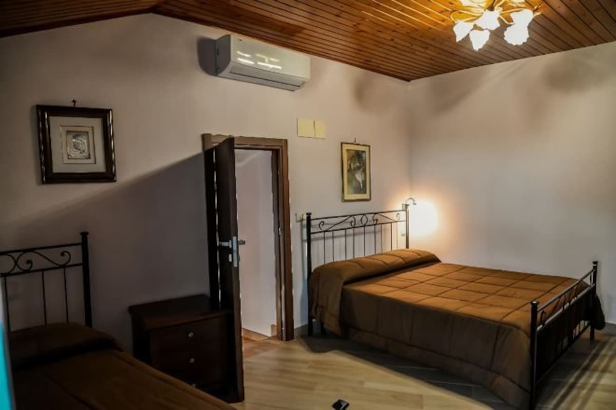 Un dormitorio con cama, cómoda, puerta y ventilador de techo.