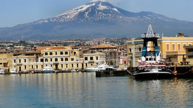 A harbor with a boat docked in front of a mountain. - Etna Dimora dei Saponari (Trecastagni)