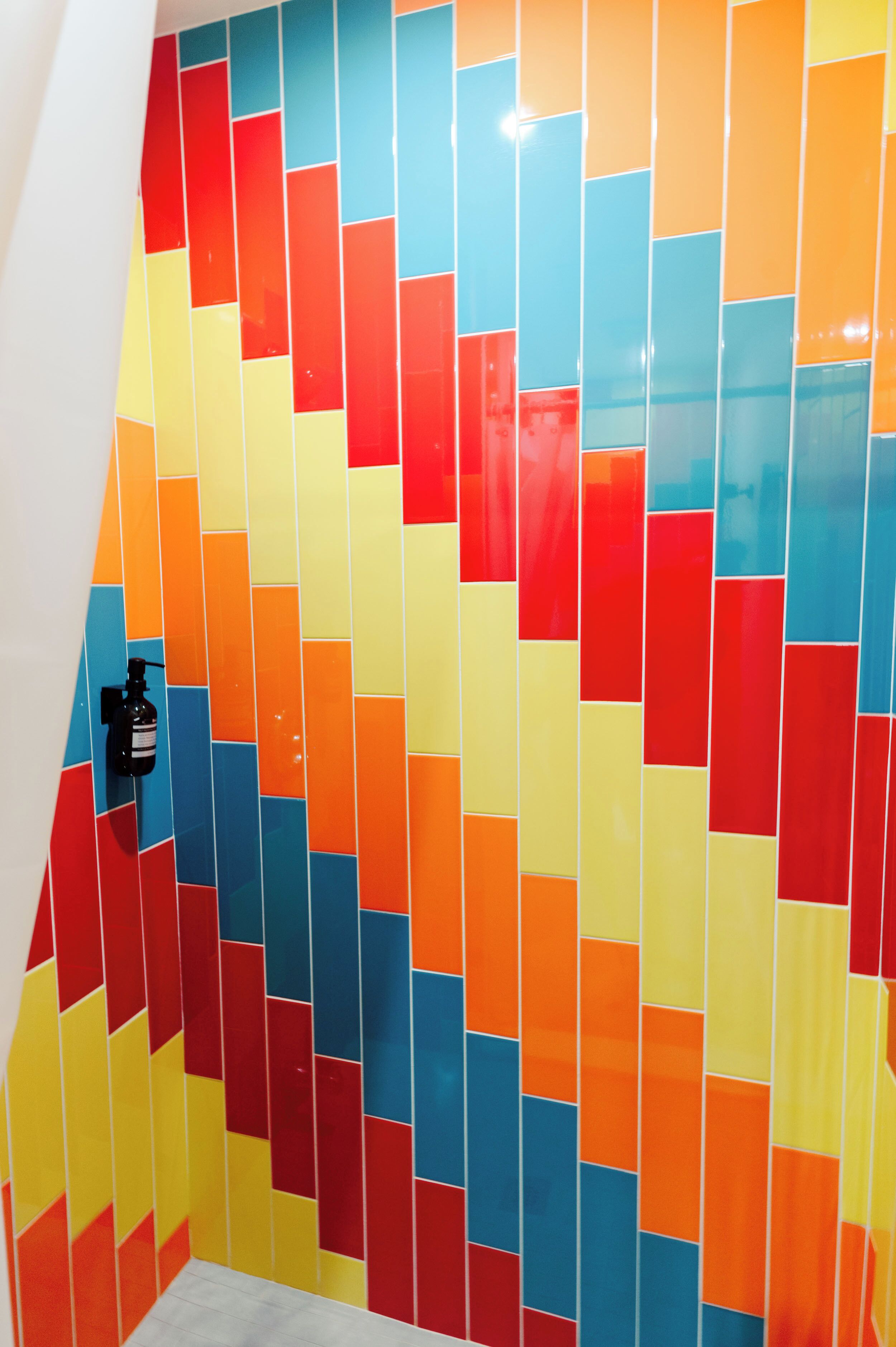 Una pared vibrante con azulejos multicolores y un diseño geométrico.