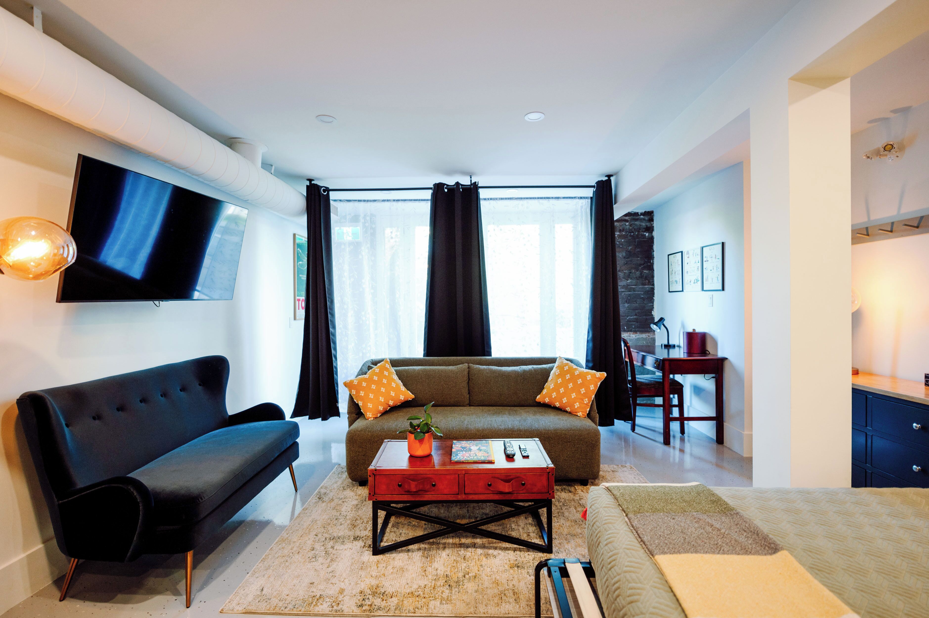 A modern living room with a sofa, a coffee table, and a TV mounted on the wall.