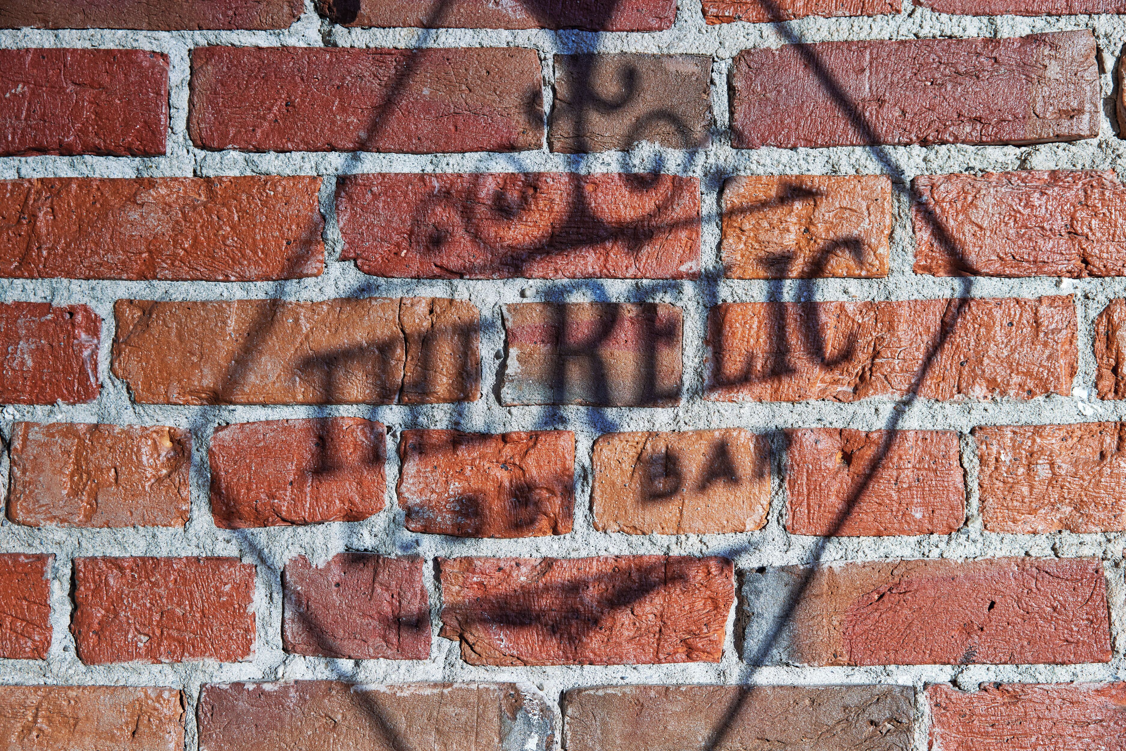 A brick wall with graffiti.