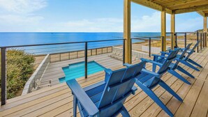 A wooden deck with a pool and lounge chairs overlooking the ocean. - Premier Soundfront w/ Pool, Hot Tub, Elevator, EV Charger, Pickleball, Theater (Rodanthe)