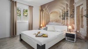 A modern bedroom with a large bed, two bedside tables, a mural of an architectural corridor, and a window with curtains. - Seafront Villa Azzurro with heated pool, panoramic sea views, walking distance to beach-shop-restaurant (Stanici)