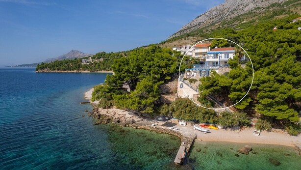 An aerial view of a coastal property with a house surrounded by trees, a dock, and clear blue waters. - Seafront Villa Azzurro with heated pool, panoramic sea views, walking distance to beach-shop-restaurant (Stanici)