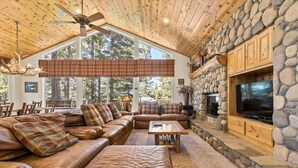 A spacious living room with leather sofas, a stone fireplace, and a television. - Getting Away Together 6 Bedroom Home by RedAwning (South Lake Tahoe)