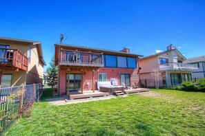 Ein zweigeschossiges Haus mit Terrasse, Whirlpool und umzäunter Garten.