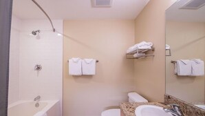 Une salle de bain moderne équipée d’une baignoire, de toilettes et d’un lavabo.