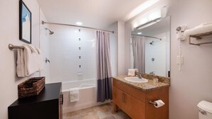 Ein modernes Badezimmer mit einer Badewanne, einer Dusche, einem Waschtisch und einem großen Spiegel.