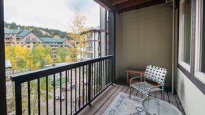 Ein Balkon mit Blick auf einen Hotelkomplex und Herbstbäume.