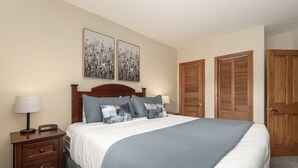 A neatly arranged bedroom with a large bed, two bedside tables with lamps, and a wooden wardrobe. - Premium Unit 1327 - One Bedroom - Zephyr Mountain Lodge 1 Condo (Winter Park)