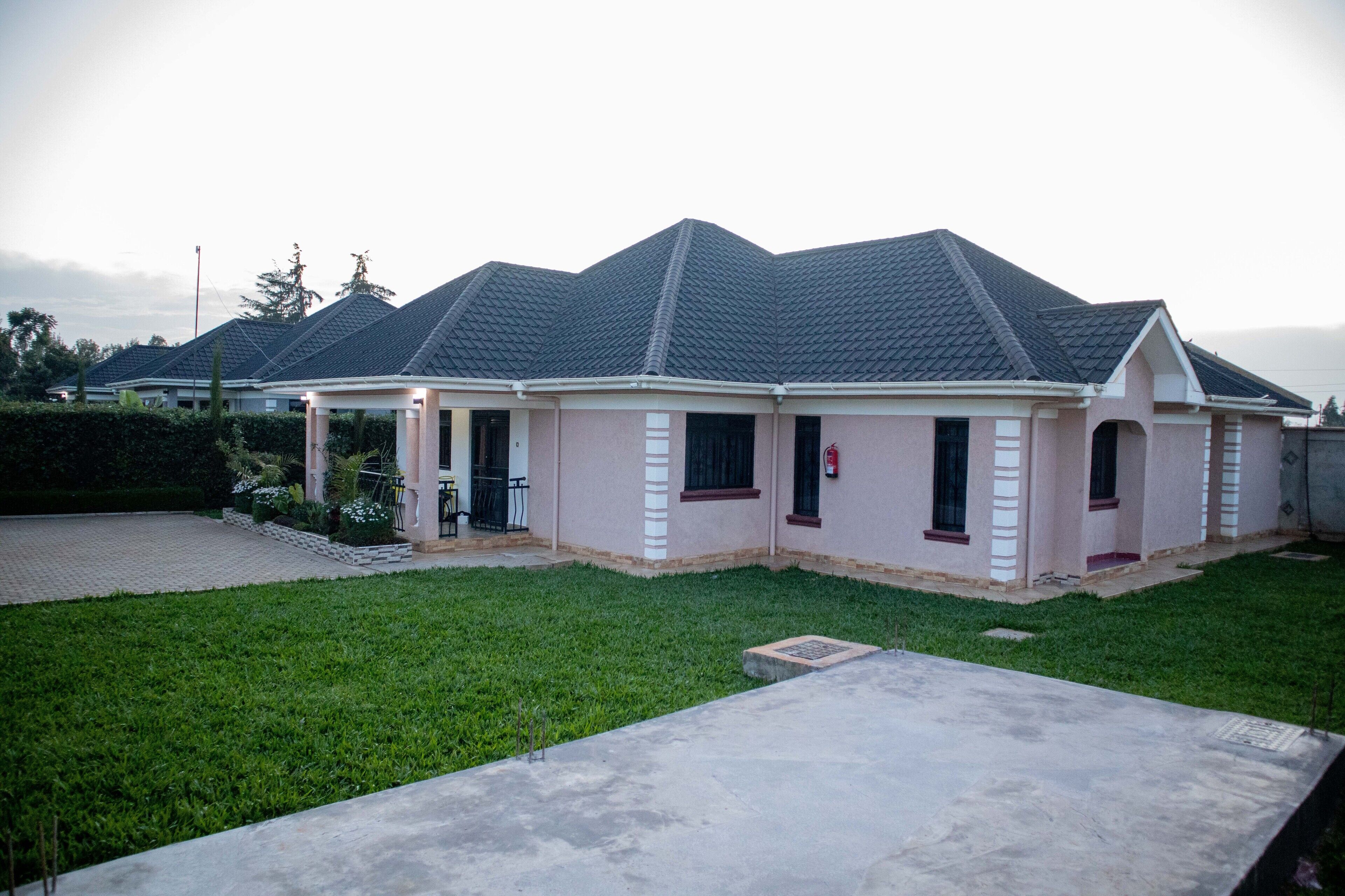 A residential house with a covered porch, a front yard, and a driveway.