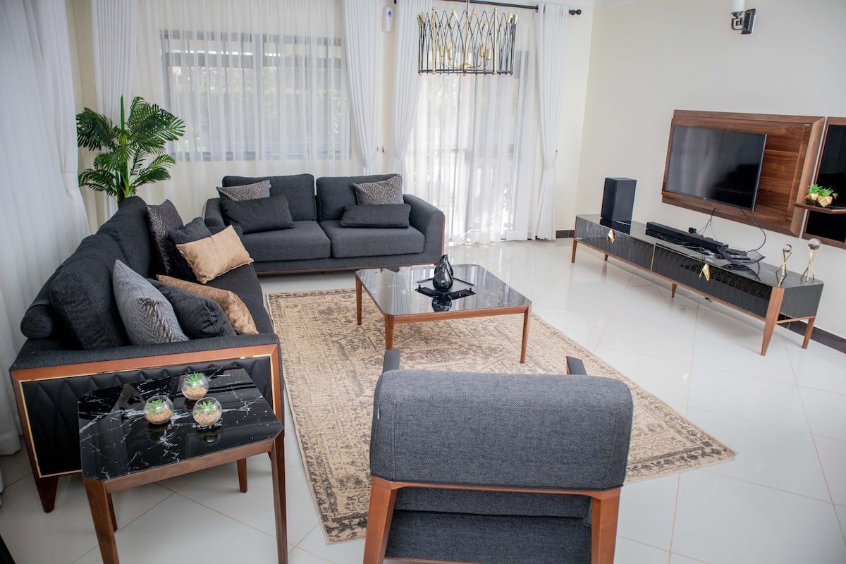 Una sala de estar moderna con sofá, mesa de centro y mueble para televisión.