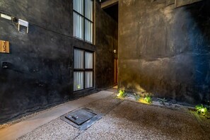 A narrow hallway with a dark wall, a window, and a small plant area. - Downtown Tulum Loft w/Rooftop Pool (Tulum)