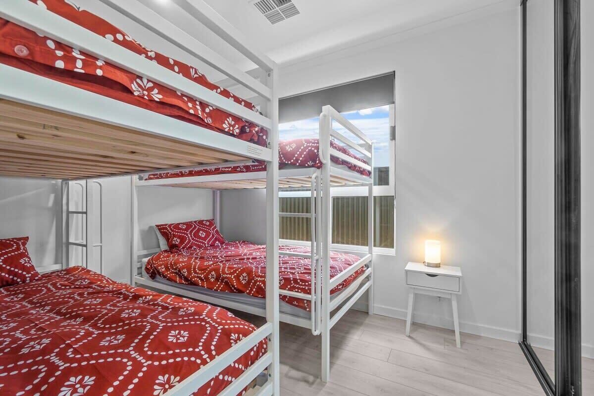 Huoneessa on kerrossängyt, yöpöytä lampun kanssa ja ikkuna, josta on näkymä.