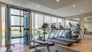 A gym with treadmills, a weight machine, and a bench. - Relaxing 2BR at Vera Residences (Dubai)