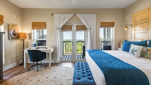 A bedroom with a bed, a desk, a chair, a balcony with curtains, and a view of the outdoors. - Lemon Squeezy + Private Beach, Pool & Beach Views (Seacrest)