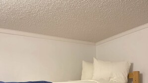 Una cama litera con estructura de madera y ropa de cama blanca.