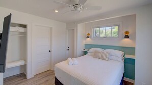 A bedroom with a bed, a ceiling fan, a window, and a wardrobe. - Walk to Beach and Town, Fire Pit, BBQ (Bungalows123) (Ocean Park)