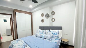 Un dormitorio con cama, ventilador de techo y una pequeña mesa.