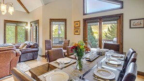 A dining area with a long table set for six, surrounded by leather chairs, and large windows providing natural light. - Rocky Mountain Retreat: 2 Mi to Beaver Creek! (Avon)