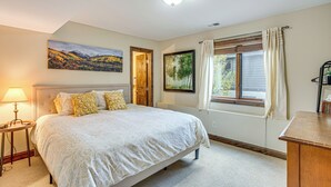 A bedroom with a bed, a bedside table, a lamp, and a window with curtains. - Rocky Mountain Retreat: 2 Mi to Beaver Creek! (Avon)