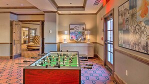 A hotel lobby with a foosball table, a sofa, a fireplace, and a painting on the wall. - Luxury Mountain Condo w/ Community Perks & Shuttle (Avon)