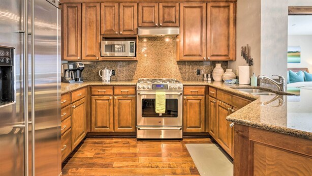 A modern kitchen with wooden cabinets, stainless steel appliances, granite countertops, and a built-in oven. - Luxury Mountain Condo w/ Community Perks & Shuttle (Avon)