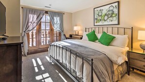 A hotel room with a bed, a desk, a chair, a lamp, and a painting on the wall. - Luxury Mountain Condo w/ Community Perks & Shuttle (Avon)