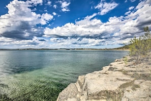A coastal landscape with clear water, rocky shoreline, and distant land under a partly cloudy sky. - Canyon Lake Home w/ Game Room < 1 Mi to Boat Ramp! (Canyon Lake)
