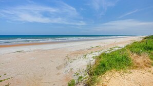Una playa con cielo despejado y mar.