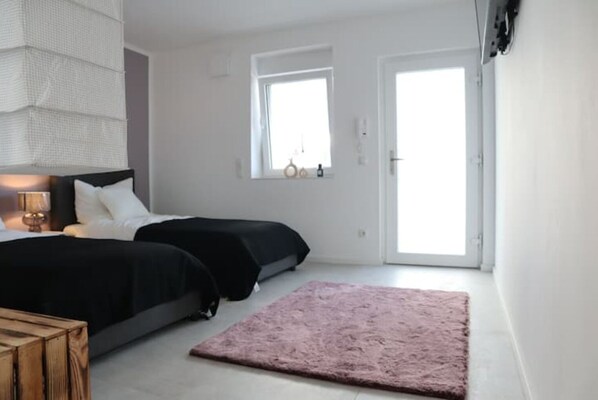 Two single beds, a nightstand, and a small table make this room a comfortable retreat.
