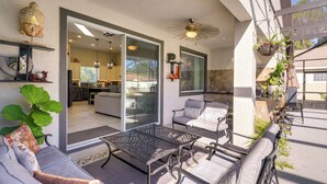 A patio with outdoor furniture, a ceiling fan, and a view into the house.