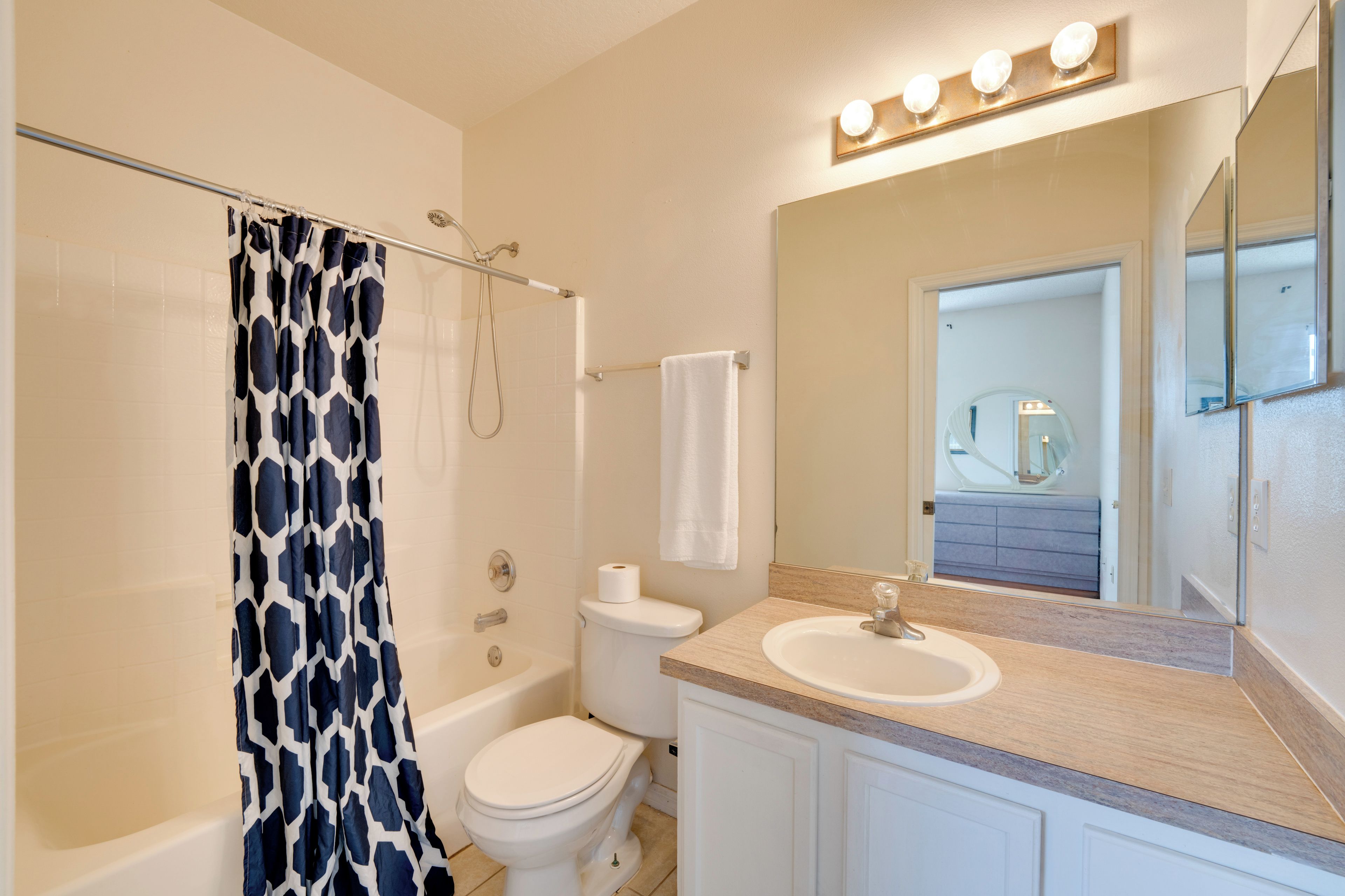 A bathroom with a bathtub, toilet, and sink.